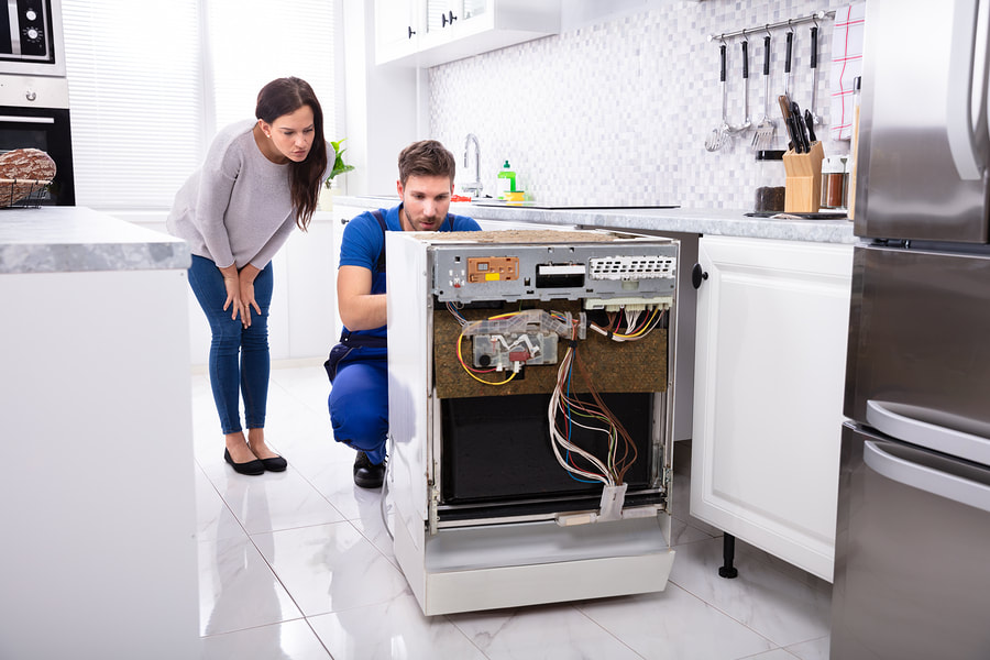 a man and a woman fixing a stove