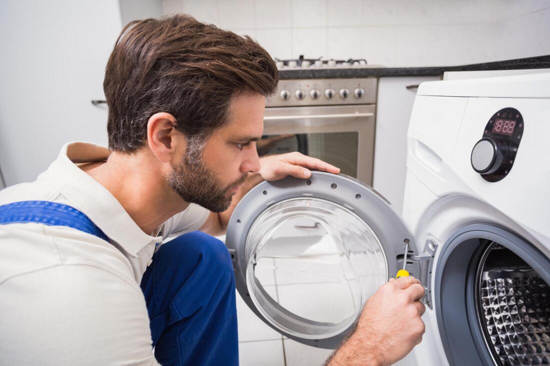 man putting screws on dryer